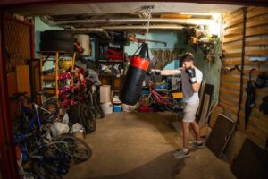 A person punching a punching bag in a garage